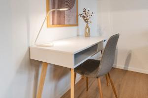 a white desk with a chair and a lamp at COZY 1 !Gratis Parken, Free Parking! in Weinfelden