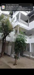 a white building with a tree in front of it at Tash Studios in Diani Beach