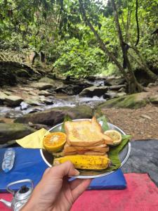 a plate of food with a banana and bread at Bukit Lawang Orangutan Dormitory in Bukit Lawang