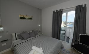 een slaapkamer met een bed en een raam met een balkon bij Paulos Valletta in Valletta