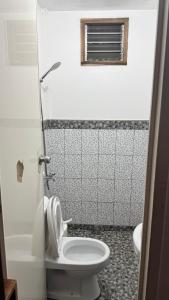 a bathroom with a toilet and a window at Port Barton - Paradiso Azul Campsite Beachfront with Internet in San Vicente