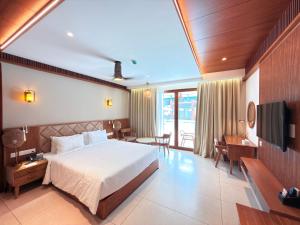 a hotel room with a bed and a television at KTDC Malabar Courtyard in Mulappilangād