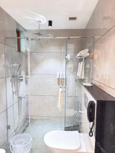 a bathroom with a glass shower with a toilet at KTDC Malabar Courtyard in Mulappilangād +8 photos