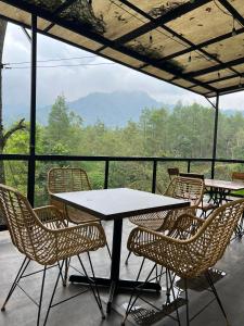 a group of tables and chairs on a balcony at Pagupon Camp Syariah in Batu
