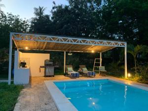 a pergola over a swimming pool in a backyard at Nyotas gem in Watamu +30 photos
