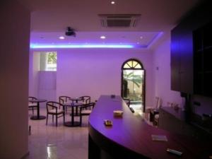 a living room with purple lighting and tables and chairs at Brazil Hotel in Athens