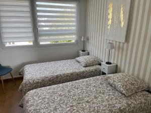 two beds in a small room with a window at Appartement vue mer in Bénodet