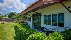 a porch of a house with a table and chairs at Lipa Bay Residence in Nathon Bay