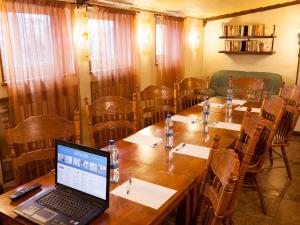 a conference room with a laptop on a wooden table at Amsterdam Hotel in Saint Petersburg