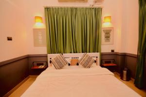 a bedroom with a bed with a green curtain at Hotel Gargo Tower in Guwahati
