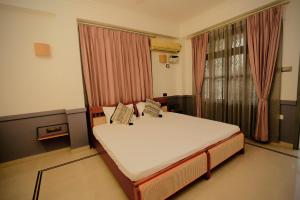 a bedroom with a bed and a large window at Hotel Gargo Tower in Guwahati