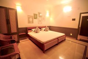 a bedroom with a bed and a chair at Hotel Gargo Tower in Guwahati