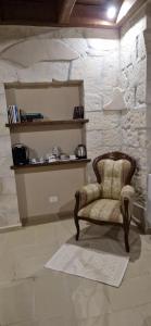 a chair sitting in a room with a stone wall at Il Lentisco in Codrongianos