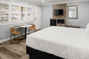 a bedroom with a large bed and a table and chairs at Lone Oak Lodge in Monterey