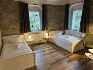 two beds in a room with two windows at Hotel Hohe Reuth in Bocka