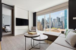 a living room with a couch and a large window at Andaz 5th Avenue, By Hyatt in New York