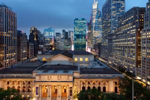 a building in the middle of a city at night at Andaz 5th Avenue, By Hyatt in New York