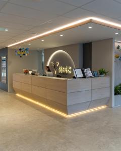 a reception desk in a lobby with a woman in aermottermottermottermottermott at Hotel Senec Aqua Resort - Family friendly in Senec