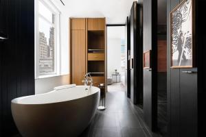 a bathroom with a white tub in a black room at Andaz 5th Avenue, By Hyatt in New York +111 photos