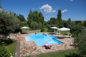 a swimming pool in a yard with umbrellas at Agriturismo Tre Querce in Penna San Giovanni
