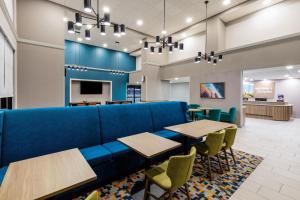 a living room with a blue couch and tables at Hampton Inn & Suites by Hilton Tomball Houston NW in Tomball