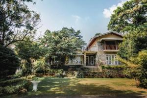 a large house with a yard with trees at Summit resort in Balangoda