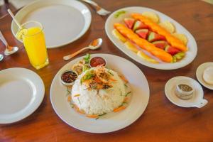 a wooden table with plates of food and fruits and vegetables at Summit resort in Balangoda