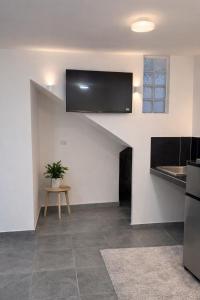 a kitchen with a sink and a tv on the wall at Downtown, Comfortable Loft, in Hermosillo