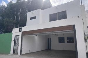 a white building with a garage with a door at Downtown, Comfortable Loft, in Hermosillo +2 photos