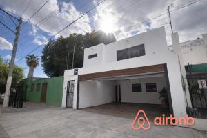 a white building with a garage in front of it at Downtown, Comfortable Loft, in Hermosillo