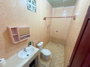 a bathroom with a toilet and a sink at Harus Damai Inn in Lagudri