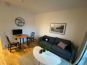 a living room with a blue couch and a table at Nice flat in Barkarby in Järfälla
