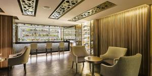a restaurant with a bar with chairs and tables at Hotel Marbella in Mexico City