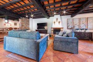 a living room with two blue couches and a fireplace at La Quintana de Los Valles in Benia de Onís