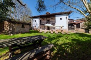 a house with chairs and umbrellas in a yard at La Quintana de Los Valles in Benia de Onís