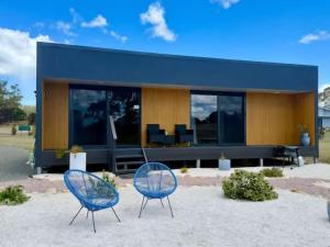 two blue chairs in front of a building at Swansea Cabins in Swansea