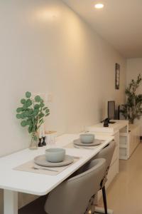a white kitchen with two bowls on a counter at Elegant Modern White Suite in Chiang Mai +30 photos