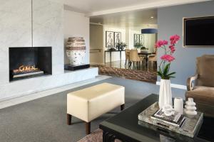 a living room with a fireplace and a chair at The Fontaine in Kansas City