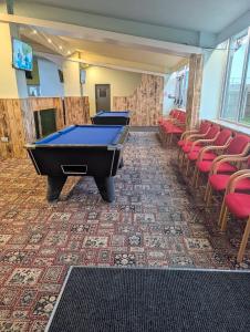a row of pool tables in a room with chairs at 116, Two bed Chalet on California Sands Holiday Park - Sleeps 5, pet friendly, includes FREE pool passes, Free Entry to Clubhouse - plus Electric, WiFi, bed linen and towels all included - only 300m from the beach! in Scratby
