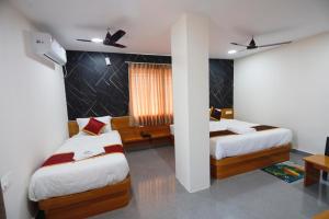 a hotel room with two beds and a window at Mantra Lodge in Shimoga