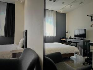 ein Hotelzimmer mit zwei Betten und einem Fernseher in der Unterkunft Hotel Sun Road in Amakusa