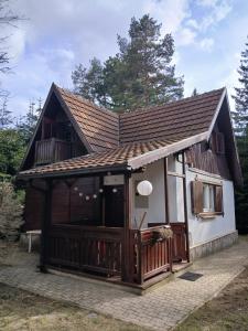 a small house with a porch and a roof at Planinska kucica Srce in Zlatibor +43 photos