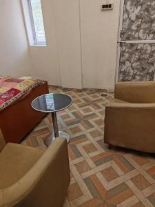 a room with a couch and a table and a chair at Cnc in Vadodara +1 photo
