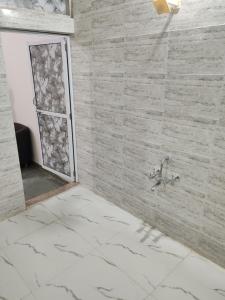 a bathroom with a shower with a stone wall at Cnc in Vadodara