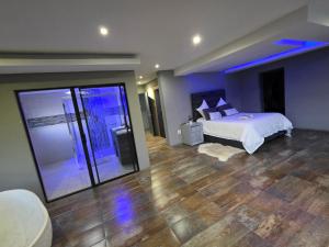a large bedroom with a bed and a glass door at XLA Home Guest house in eMalahleni +38 photos