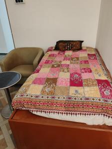 a bed with a quilt on top of it at Cnc in Vadodara