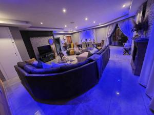 a living room with a large couch and a fireplace at XLA Home Guest house in eMalahleni