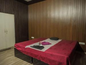 a room with a bed with a red blanket on it at The Ark Spalon Spa Gomti Nagar in Lucknow