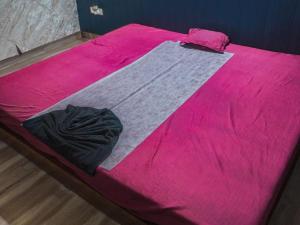 a bed with a pink blanket on top of it at The Ark Spalon Spa Gomti Nagar in Lucknow