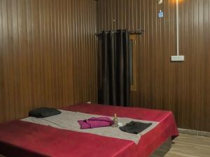 a bedroom with a bed with a red blanket at The Ark Spalon Spa Gomti Nagar in Lucknow
